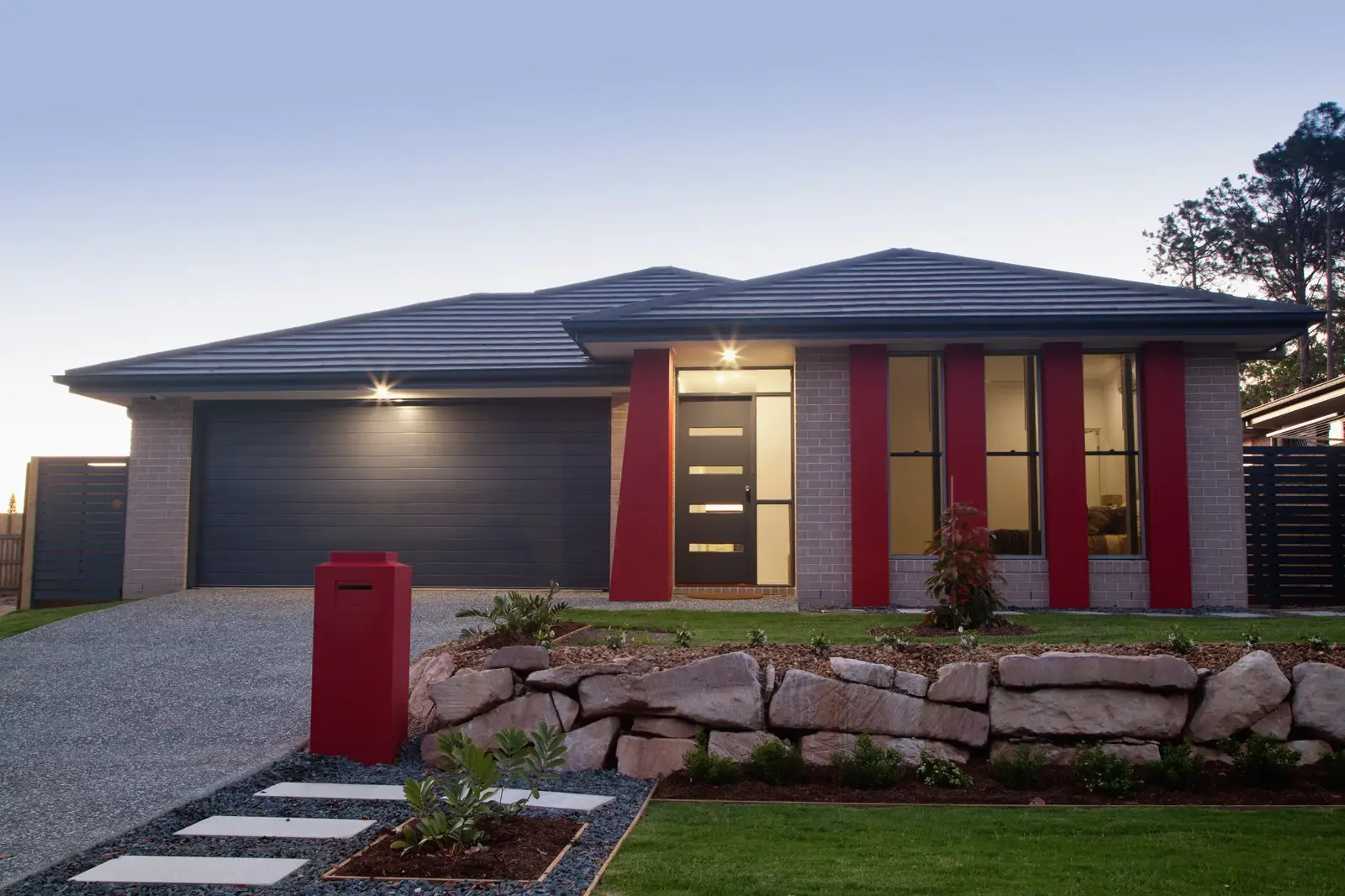 Concrete driveway leading into a home's garage at dusk